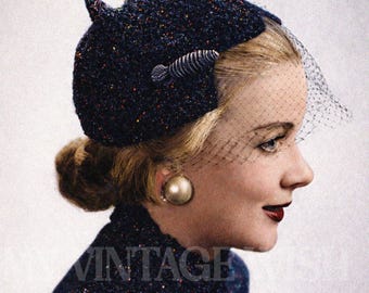 Peut inclure: Image vintage d'une femme portant un chapeau et une cravate en chenille bleu marine. Le chapeau est orné d'un élément décoratif et d'un voile délicat. L'ensemble est rehaussé d'une grosse boucle d'oreille en perle et d'un rouge à lèvres foncé. Le texte "Chenille Cravat & Hat" est visible.