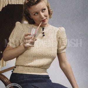 Pode incluir: Imagem de padrão de crochê vintage com uma mulher usando um top creme de mangas curtas com botões e uma saia azul marinho. O texto "RETRO CROCHET" e "Projetado para um busto de 86-89 cm" são visíveis. Estética retrô.