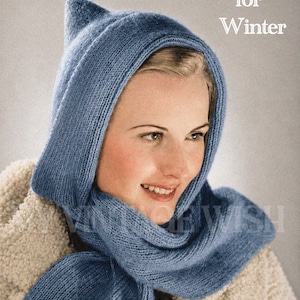 Puede incluir: Una capucha de punto azul con bufanda integrada, que presenta un diseño de punta en la parte superior. El texto "Hood for Winter" está impreso en blanco en la esquina superior derecha. El accesorio está hecho de hilo suave y texturizado.