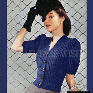 Peut inclure: Un gilet en tricot bleu marine à manches courtes avec une texture côtelée, un col en V et quatre boutons foncés sur le devant. Le vêtement est conçu pour un tour de poitrine de 84 à 89 cm. L'image contient le texte 231, VINTAGE WISH et RETRO KNITTING.