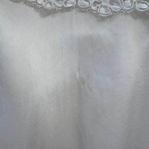 May include: White satin fabric with a white lace trim at the top.