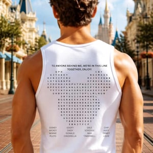 May include: A white tank top featuring black text on the back. The text reads, TO ANYONE BEHIND ME, WE'RE IN THIS LINE TOGETHER, ENJOY! Below this is a heart-shaped word search puzzle containing various names, followed by a list of character names.