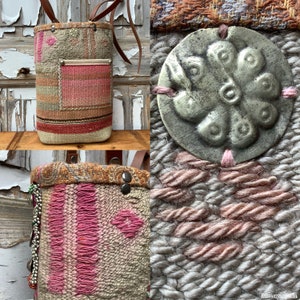 Puede incluir: Un bolso tejido de tapicer&iacute;a con un patr&oacute;n rosa y marr&oacute;n. El bolso tiene un bot&oacute;n grande, redondo, de metal plateado con un dise&ntilde;o floral. El bolso tiene una correa de cuero y un peque&ntilde;o bolsillo en la parte delantera.