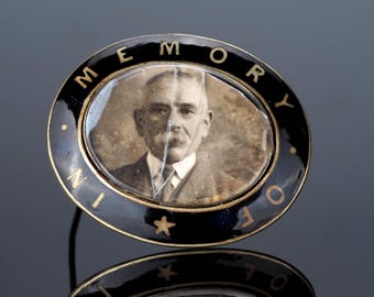 Victorian Mourning brooch; with black enamel and In Memory Of text. Has picture and glass front is cracked