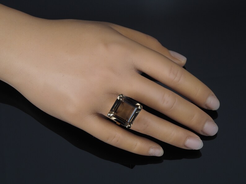 May include: A gold ring with a large, square-shaped smoky quartz gemstone.