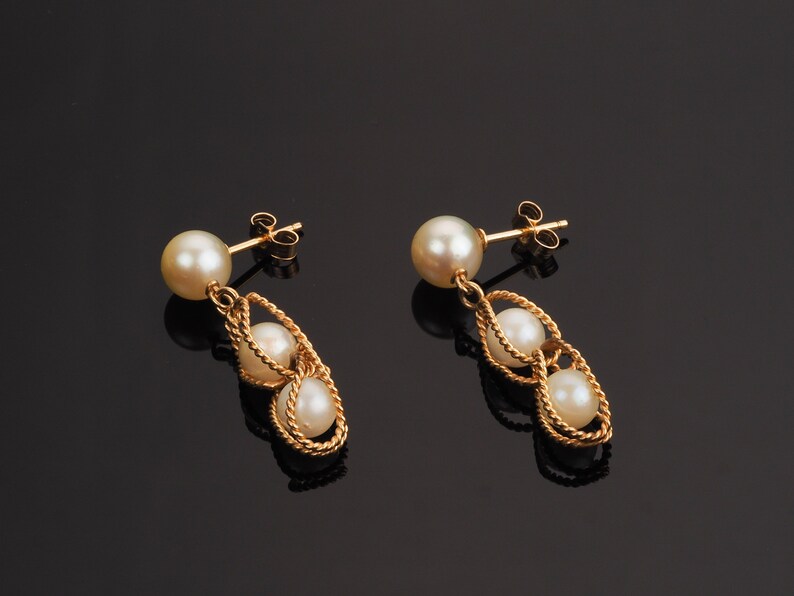 Vintage gold pearl earrings with a round pearl on gold post and drop dangle two pearls held within a ropetwist basket of gold.  Pearls are a beautiful oyster.