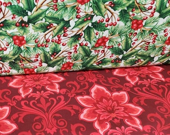 Könnte beinhalten: Zwei Stoffmuster, eines mit weißem Hintergrund und einem Muster aus grünen Stechpalmenblättern und roten Beeren, das andere mit einem roten und burgunderfarbenen floralen Damastmuster.