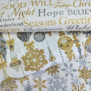 May include: White fabric with a gold and silver Christmas print. The fabric features snowflakes, ornaments, and the words "Good Will", "Night Hope", "Seasons Greetings", and "Christmas Wishes".