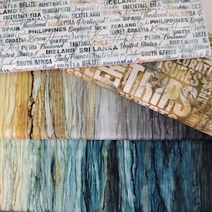 May include: Three fabric swatches with a wood grain pattern. The top swatch has a white background with brown and yellow streaks. The middle swatch has a gray background with brown and white streaks. The bottom swatch has a blue background with green and black streaks. The top swatch has a white background with text in black, including the word "Trips".