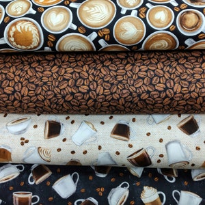 May include: Three fabric swatches with a coffee theme. The top swatch features a black background with white coffee cups and brown coffee beans. The middle swatch features a brown background with white coffee beans. The bottom swatch features a black background with white coffee cups and brown coffee beans.