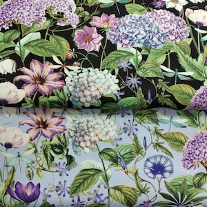 May include: A floral fabric with a black background and a blue background. The black background features large white and blue hydrangeas, purple and white flowers, and green leaves. The blue background features white and blue hydrangeas, purple flowers, and green leaves.