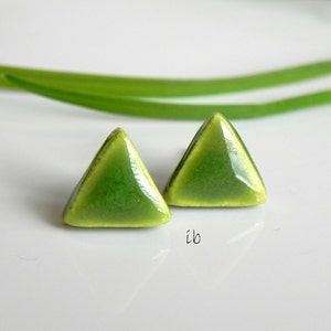 Puede incluir: Un par de pendientes de cerámica de forma triangular verde.