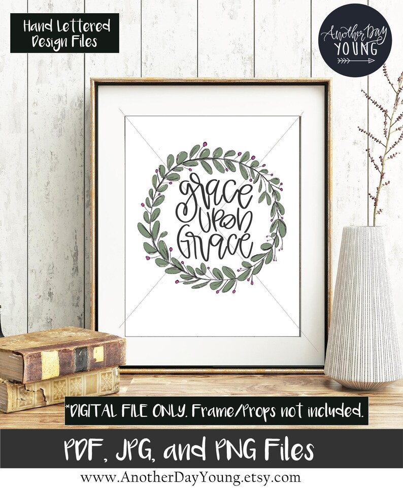 May include: A printable digital download of a hand-lettered quote, "grace upon grace", surrounded by a wreath of green leaves and pink berries. The quote is in black ink and the background is white.
