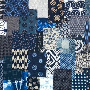 Pode incluir: Uma composição têxtil de patchwork apresentando uma variedade de quadrados de tecido em azul índigo e branco. Os padrões incluem formas geométricas, motivos florais, libélulas, ondas, círculos, pontos e designs tradicionais.