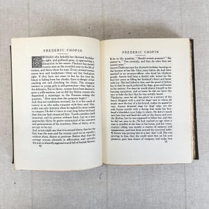 May include: Open book with text titled "FREDERIC CHOPIN" on both pages. The left page has text about a woman's thirtieth birthday. The right page discusses women proposing. The pages are aged with a dark binding.