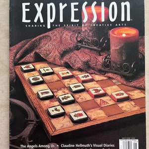 May include: A magazine cover titled "Expression" with the subtitle "Sharing the Spirit of Creative Arts." The cover features a checkerboard with decorative pieces, two lit candles, and the text "Artful Checkerboard." Additional text includes article titles.