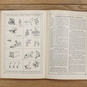 Pu&ograve; includere: Un libro vintage con un'illustrazione in bianco e nero di una pianta e il testo "Can you read these names of plants?" sulla pagina sinistra. La pagina destra contiene il testo "Making Anagrams as a Pastime" e una descrizione di come fare gli anagrammi.