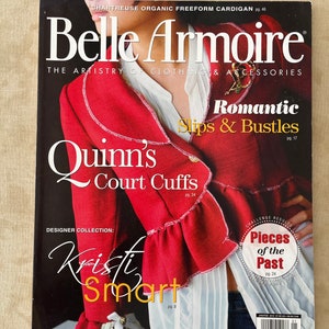 May include: A magazine cover featuring a red jacket with white lace trim and the text "Belle Armoire: The Artistry of Clothing & Accessories". The magazine cover also features the text "Quinn's Court Cuffs" and "Romantic Slips & Bustles".