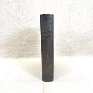 May include: A vintage book spine with embossed text. The title "Little Journeys" is visible, along with the author's name, Hubbard, and the volume number, XII. The spine is dark brown with gold lettering.