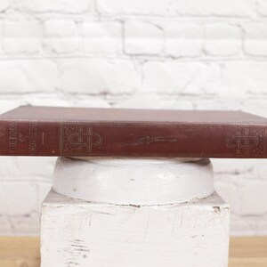 Pu&ograve; includere: Un libro vintage, rosso, rilegato in tela con lettere dorate sul dorso che recitano "The Book of Novel Letters".