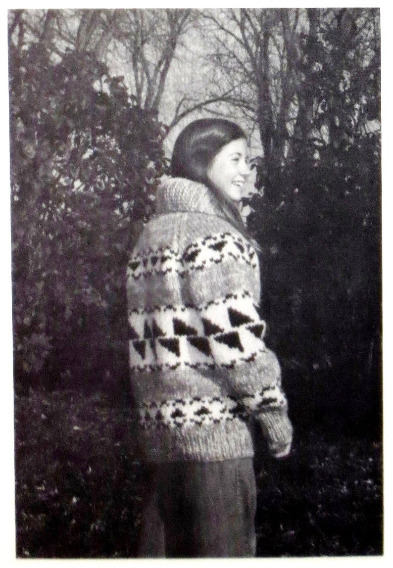 May include: A black and white patterned sweater with a high neck