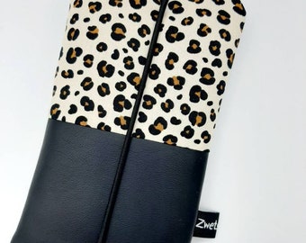 Peut inclure: Une coque de téléphone à imprimé léopard noir et blanc avec un fond en cuir noir et un élastique noir. La coque porte une étiquette blanche avec le mot "Zwet" dessus.