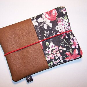 May include: A brown leather and floral fabric pouch with a red elastic band closure. The pouch has a black label with the word "Zwei" on it.