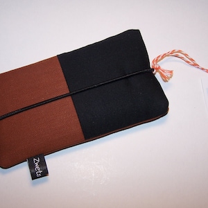 May include: A brown and black fabric phone case with a black elastic band and a black tag that says "Zwets".