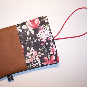 May include: A small brown and black floral pouch with a red elastic loop handle. The pouch has a brown fabric flap with the word "Zweed" printed on it.
