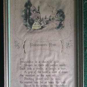 Könnte beinhalten: Ein gerahmter Druck mit dem Titel Friendship's Road, der eine Vintage-Illustration von Figuren auf einem Weg bei Häusern zeigt. Unter dem Bild steht der Text: Friendship is a chain of gold, Shaped in God's all perfect mold; Each link a smile.