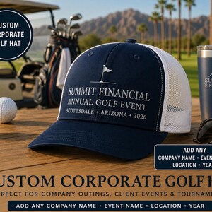 May include: A navy blue and white trucker hat featuring a white embroidered golf flag icon and the text SUMMIT FINANCIAL ANNUAL GOLF EVENT SCOTTSDALE ARIZONA 2026. The hat has a solid navy front panel and a white mesh back panel with a curved brim.
