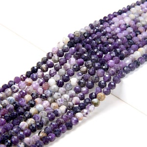 May include: A strand of faceted amethyst beads in shades of purple, lavender, and white. The beads are round and have a slightly irregular shape.