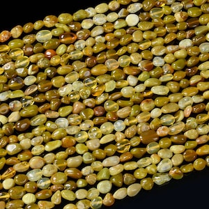 Peut inclure: Un brin de perles de pierres précieuses jaunes et vertes. Les perles sont de forme ovale et ont une finition lisse et polie.