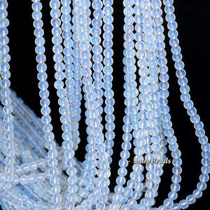 May include: A strand of light blue opal beads. The beads are round and smooth, and they have a slight iridescent sheen.