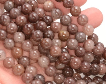 Puede incluir: Una hebra de cuentas redondas de piedra preciosa de color marrón y translúcido. Las cuentas tienen un aspecto moteado y miden aproximadamente 8 mm de diámetro.