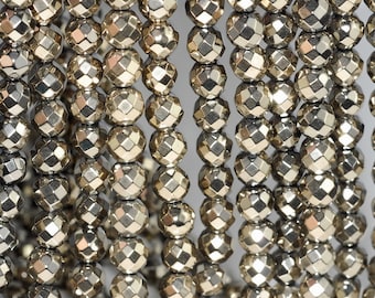May include: A strand of silver-toned faceted beads. The beads are round and have a metallic finish.
