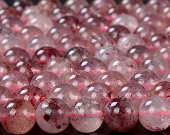 Könnte beinhalten: Nahaufnahme einer Reihe runder, durchscheinender rosa und roter Edelsteinperlen. Die Perlen haben eine gesprenkelte Optik und sind in einer Reihe angeordnet.