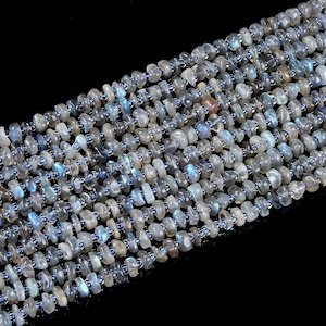 May include: A strand of iridescent blue-grey labradorite gemstone beads. The beads are smooth and oval-shaped, with a slightly irregular, natural look.