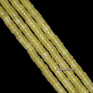 May include: A strand of pale yellow square beads, made of natural stone, with a close-up view of the beads. The beads are strung on a clear thread. The image includes the text "Snap Beads - ".