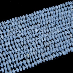 May include: A strand of light blue gemstone beads, each bead is a smooth, irregular oval shape.