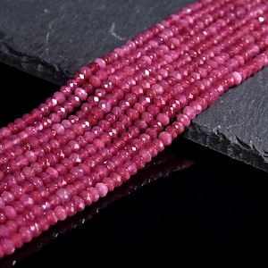May include: A strand of pink faceted gemstone beads. The beads are small and round, and they are strung together on a clear thread.