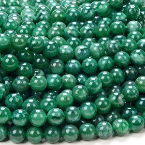 May include: A strand of smooth, round, green jade beads. The beads are all approximately the same size and have a polished finish.