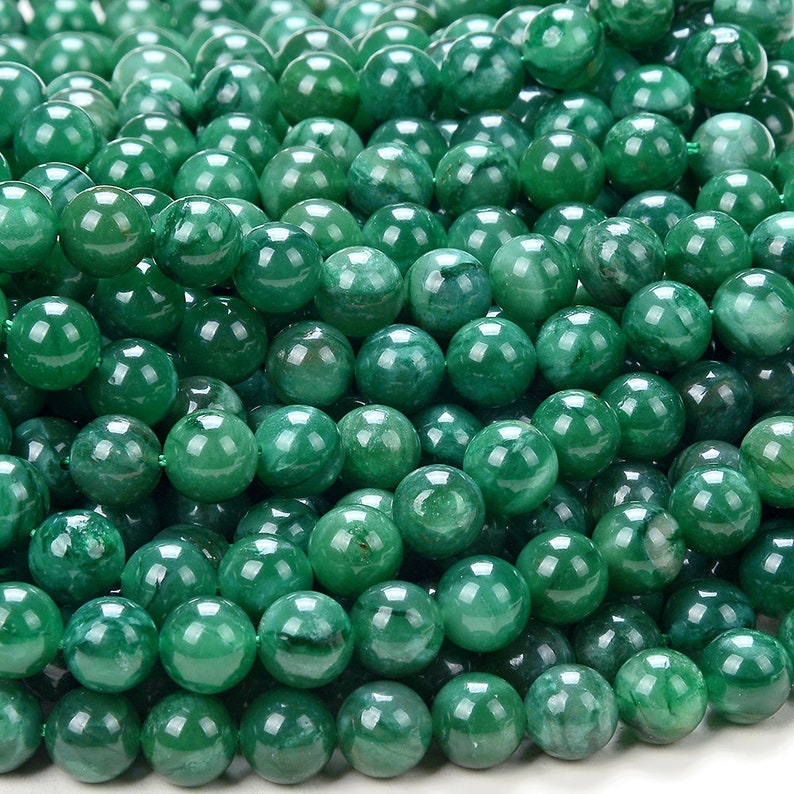 May include: A strand of smooth, round, green jade beads. The beads are all approximately the same size and have a polished finish.