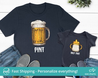 May include: Matching navy blue t-shirts for adults and babies. The adult shirt features a cartoon illustration of a beer mug with the word "PINT" underneath. The baby shirt features a cartoon illustration of a baby bottle with the words "HALF PINT" underneath.