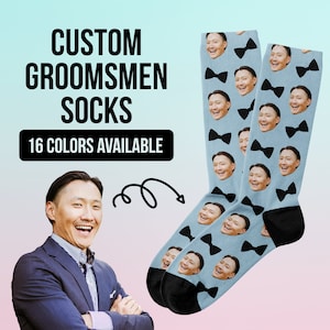 May include: A pair of blue socks with a black bow tie pattern and a man's face repeated on the fabric. The socks are shown against a pink and blue background. The text "CUSTOM GROOMSMEN SOCKS" and "16 COLORS AVAILABLE" is shown above the socks.