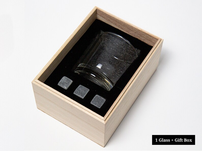 May include: A wooden gift box with a glass and four gray stone ice cubes inside. The box is open and the glass is visible. 1 Glass + Gift Box