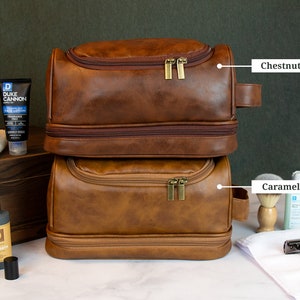 May include: Two brown leather travel bags with zippers and handles. The top bag is labeled "Chestnut" and the bottom bag is labeled "Caramel".