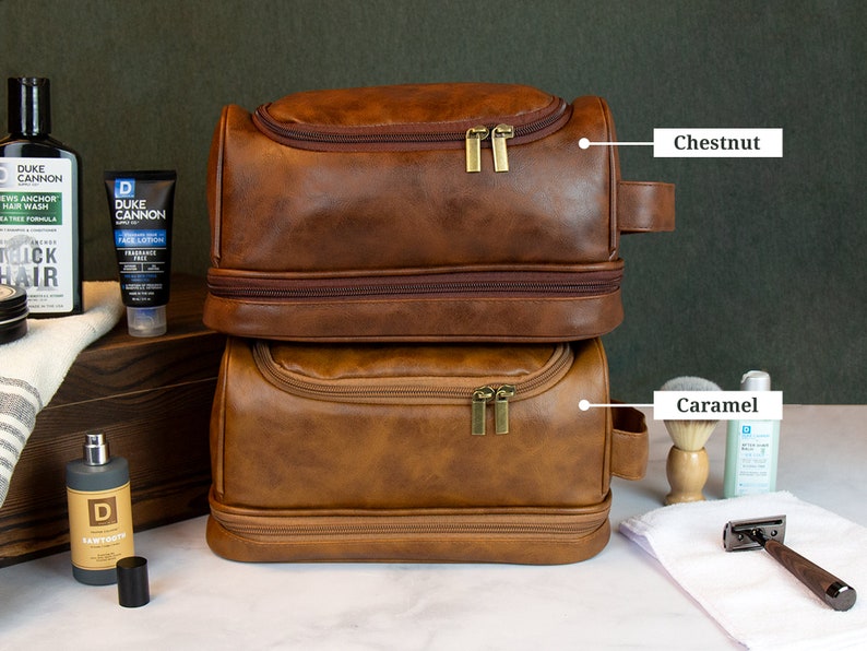 May include: Two brown leather travel bags with zippers and handles. The top bag is labeled "Chestnut" and the bottom bag is labeled "Caramel".