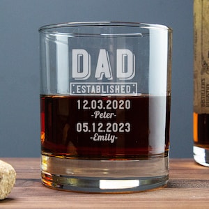 May include: A clear glass rocks glass with the text "DAD ESTABLISHED: 12.03.2020 -Peter- 05.12.2023 -Emily-" etched on the side.