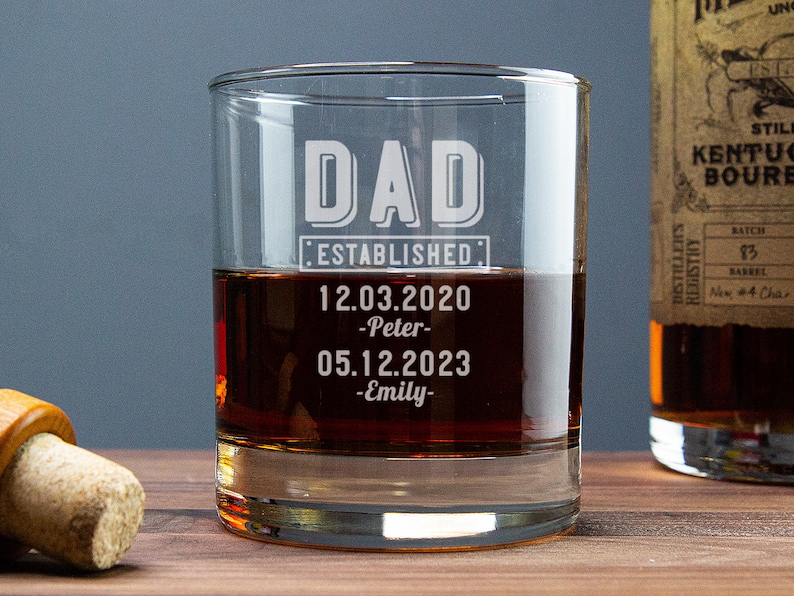May include: A clear glass rocks glass with the text "DAD ESTABLISHED: 12.03.2020 -Peter- 05.12.2023 -Emily-" etched on the side.